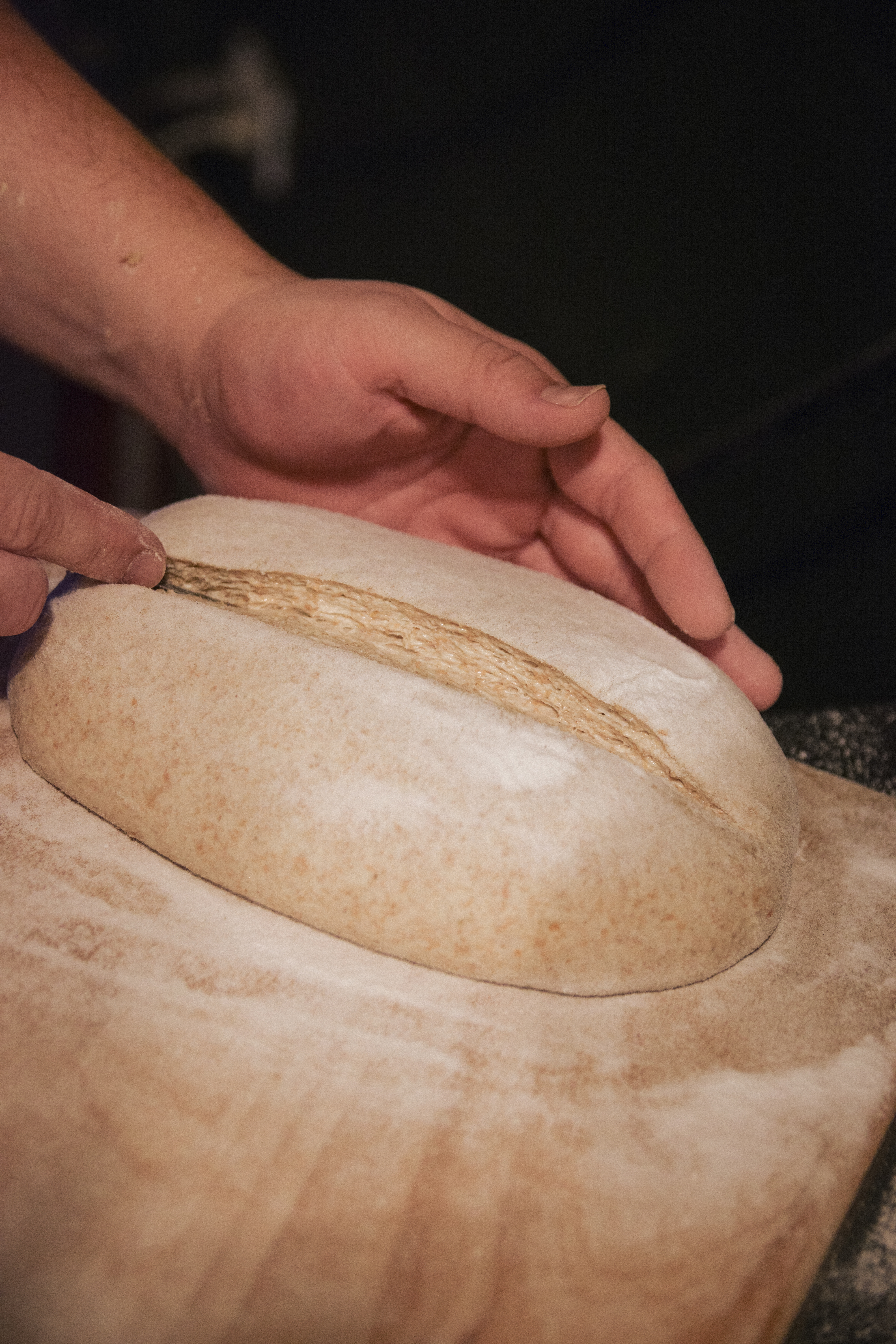 Manos formando masa sobre papel de horno en ObradorAndino